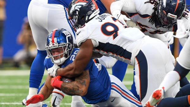 Denver Broncos defensive end Dre'Mont Jones (93) tackles New York Giants running back Devontae Booker (28) during the second half at MetLife Stadium.